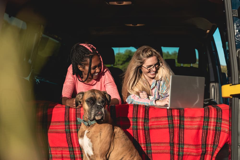 Two women camping in van with dog