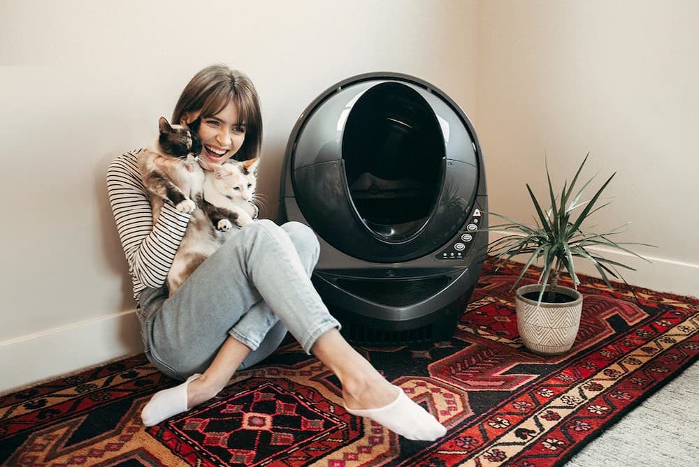 Happy cats sitting with owner and whisker litter-robot review