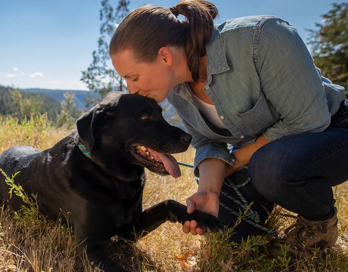 Woman smooches dog outside