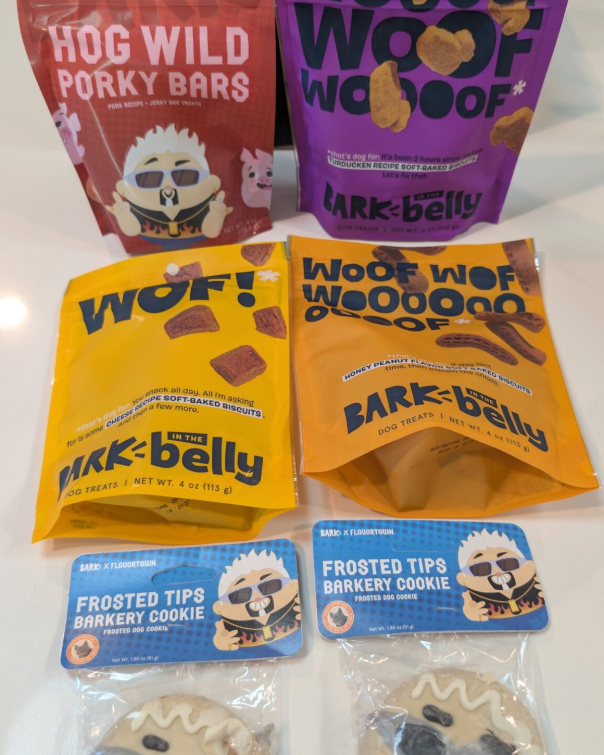 BarkBox treat lineup with Hog Wild Porky Bars, soft-baked treat bags, and two Frosted Tips Barkery Cookies